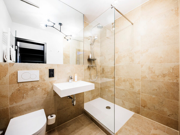 Ein elegantes und modernes Badezimmer mit Dusche im natura Hotel Bodenmais.
