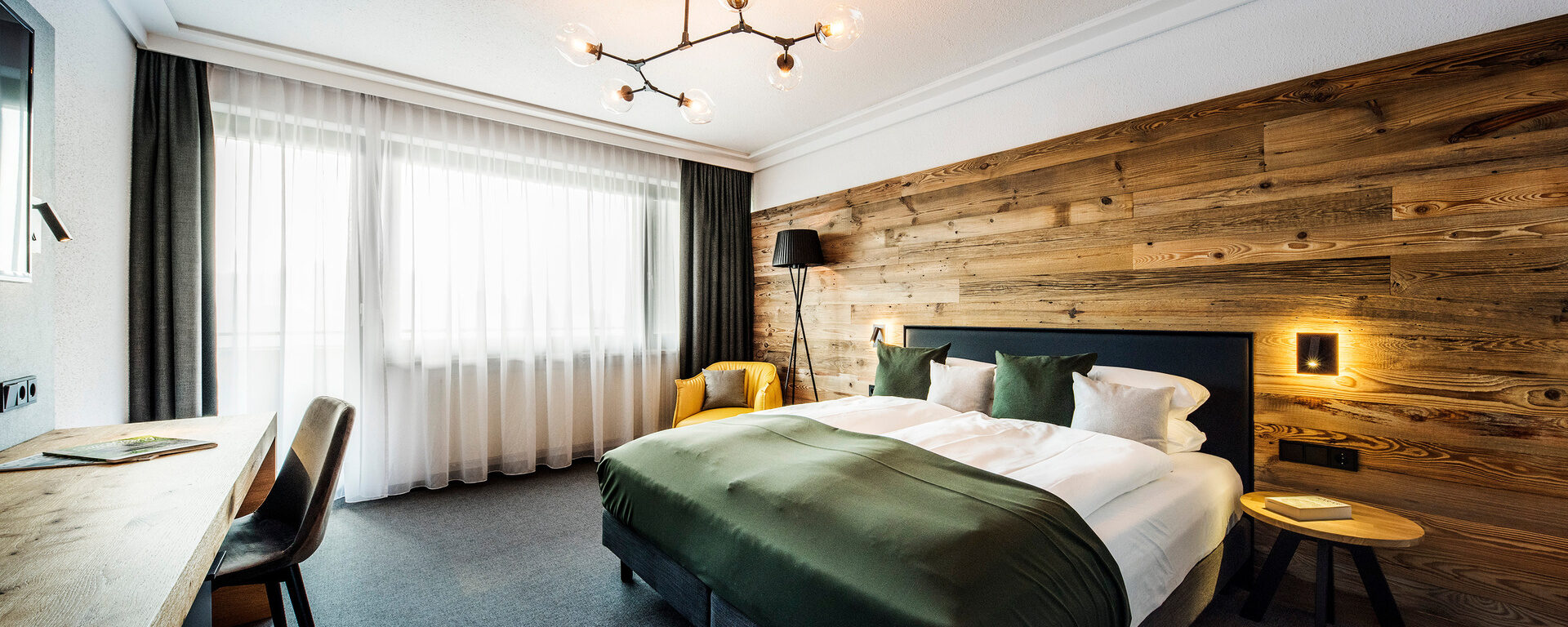Das harmonisch gestaltete Schlafzimmer im Bodenmais Comfort Zimmer mit elegantem Bettgestell und praktischem Tisch