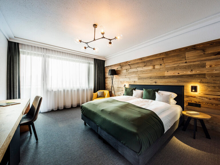 Das harmonisch gestaltete Schlafzimmer im Bodenmais Comfort Zimmer mit elegantem Bettgestell und praktischem Tisch