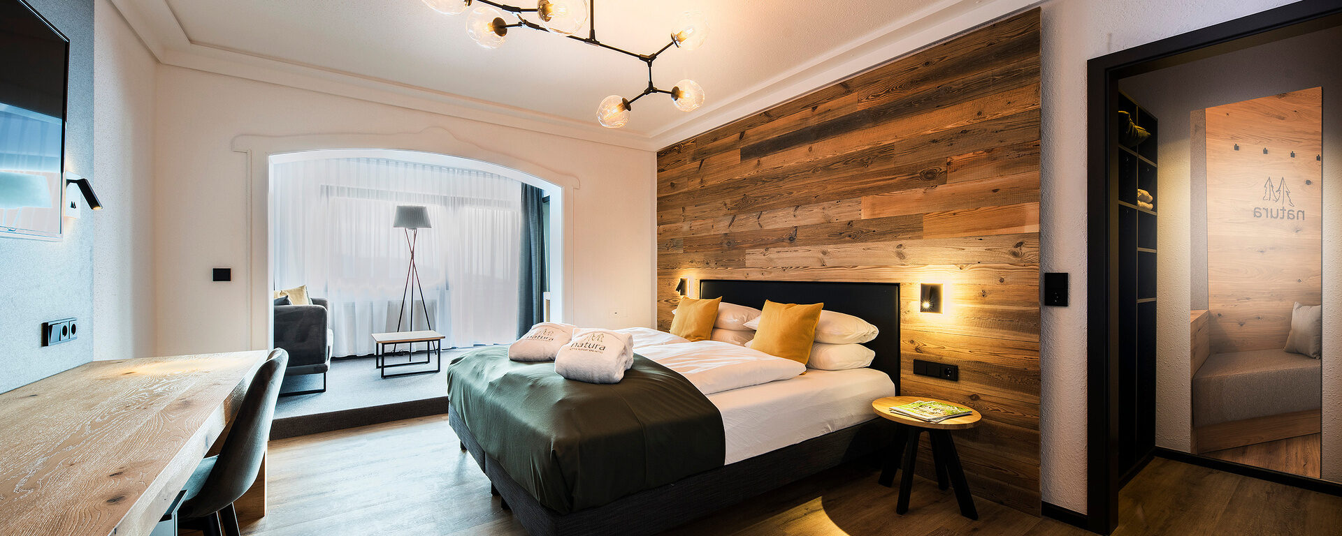 Entspannende Einrichtung im Bodenmais Superior Zimmer, die mit hochwertigen Möbeln und einem komfortablen Bett besticht.