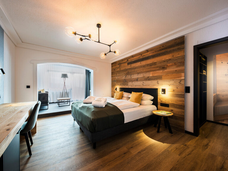 Entspannende Einrichtung im Bodenmais Superior Zimmer, die mit hochwertigen Möbeln und einem komfortablen Bett besticht.