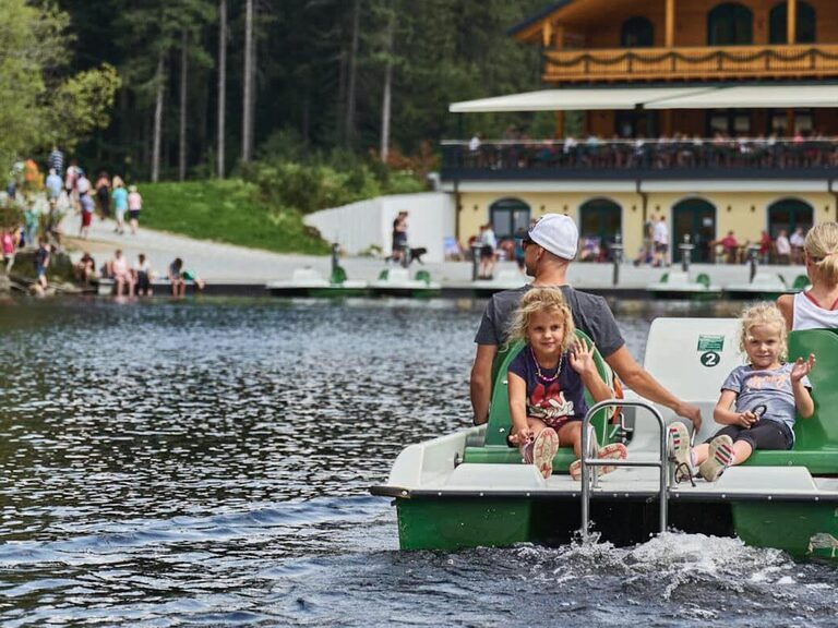 Eine Familie beim Tretboot fahren auf dem Kleinen Arbersee nahe dem natura Hotel Bodenmais.