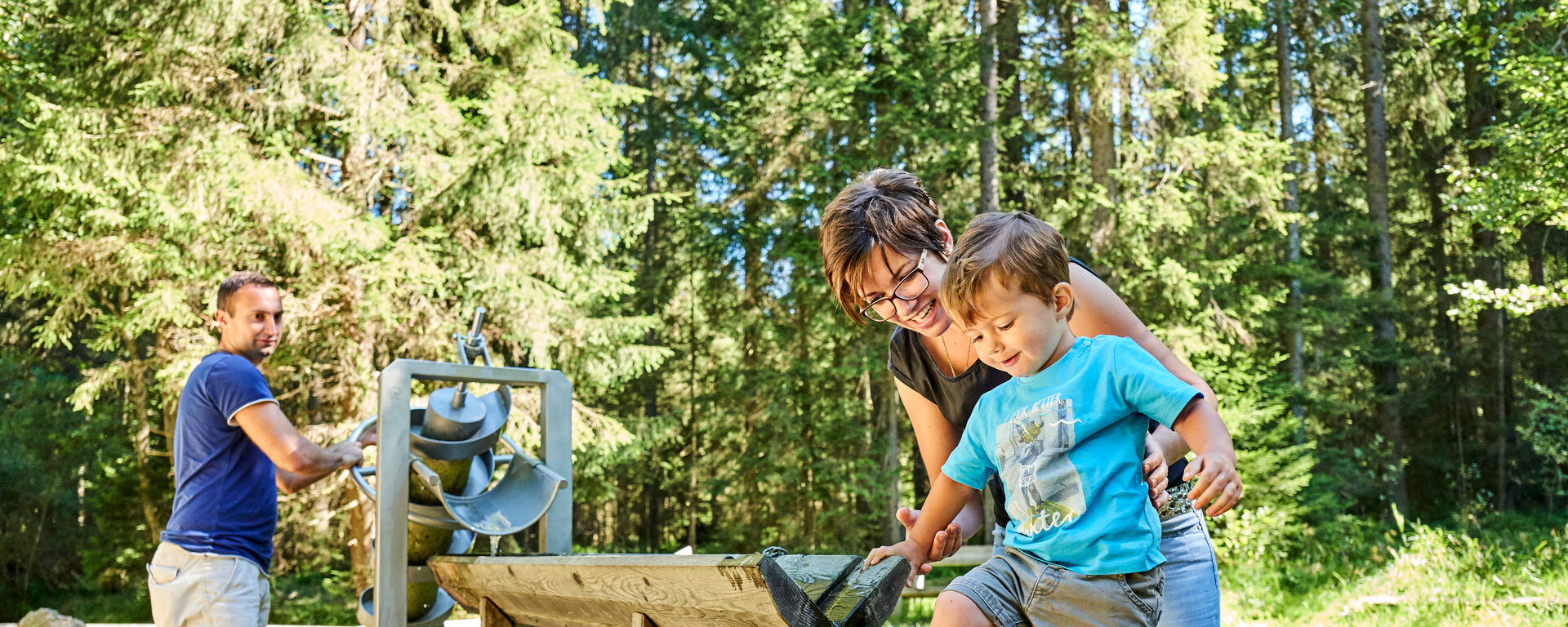 Eine junge Familie ist mit ihrem Kind im Bayerischen Wald in der nähe von Bodenmais auf Erkundungstour.