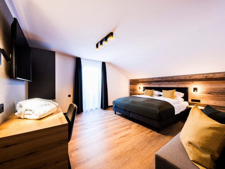 Ein gemütliches Bett im Familienzimmer des natura Hotel im Bayerischen Wald