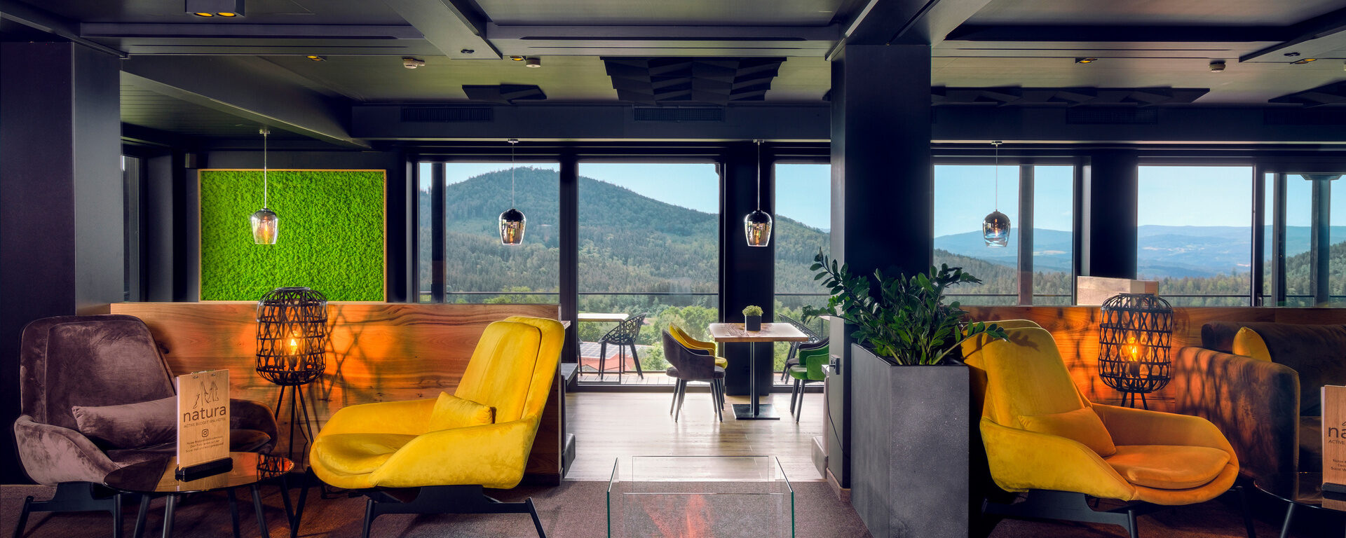 Die gemütliche Lounge im natura Hotel bietet eine einladende Feuerstelle und tolle Sitzgelegenheiten.