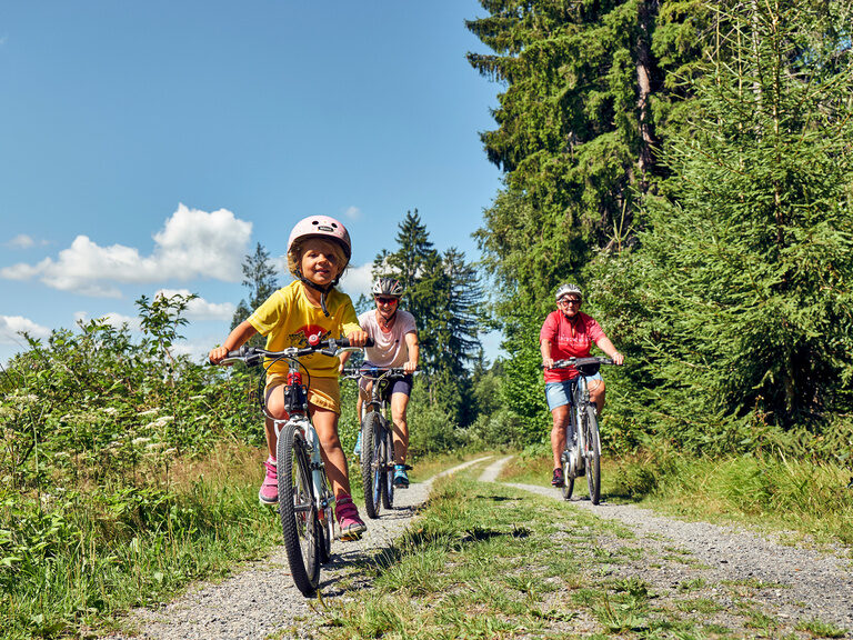 Eine Familie beim Radfahren durch den Wald in der nähe von Bodenmais