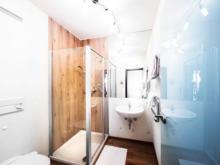 Ein elegantes Badezimmer im natura Hotel Bodenmais mit Toilette und Spiegel.