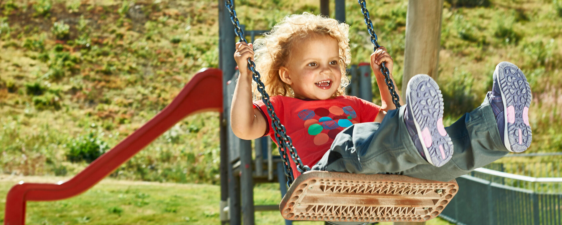Ein Kind hat großen Spaß beim schaukeln auf einem Spielplatz in der Nähe des Bayerischen Waldes.
