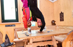 Zwei Kinder machen einen verrückten Handstand auf einem Holztisch