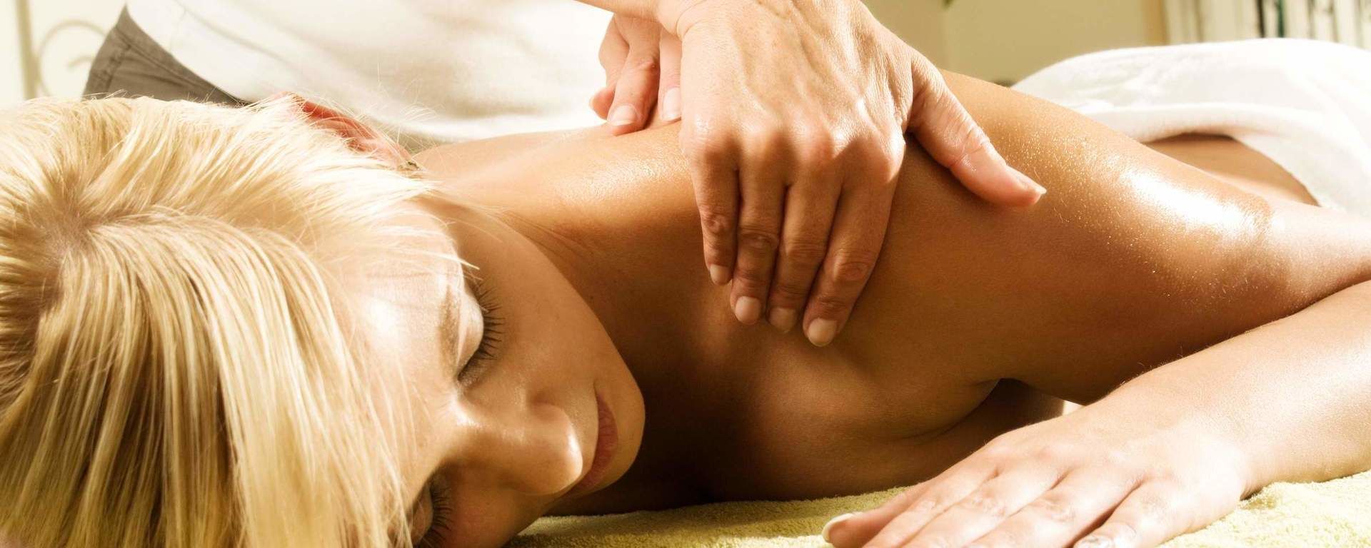 Eine Frau erhält eine Massageanwendung im natura SPA des Hotels in Bodenmais