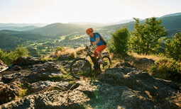 Eine Person fährt mit einem Mountainbike auf einem felsigen Pfad in der Nähe von Silberberg im Bayerischen Wald.