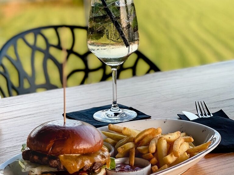 Ein berühmter natura Burger ist lecker mit Pommes angerichtet und einem Glas Win
