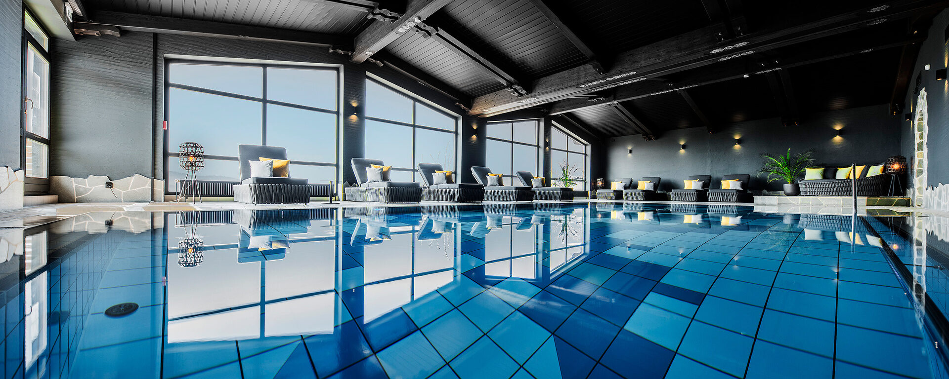 Das Panorama-Hallenbad mit blauen Fliesen im natura Hotel Bodenmais, ideal für Wellness in Bayern.