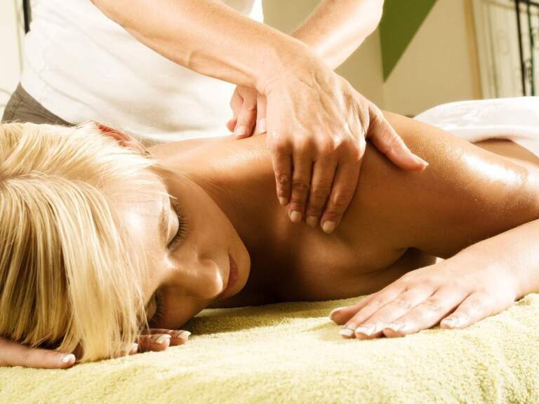 Eine Frau erhält eine Massageanwendung im natura SPA des Hotels in Bodenmais