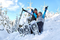 Zwei Schneeschuwanderer haben Spass und Gute Laune im Schnee im Bayerwald.