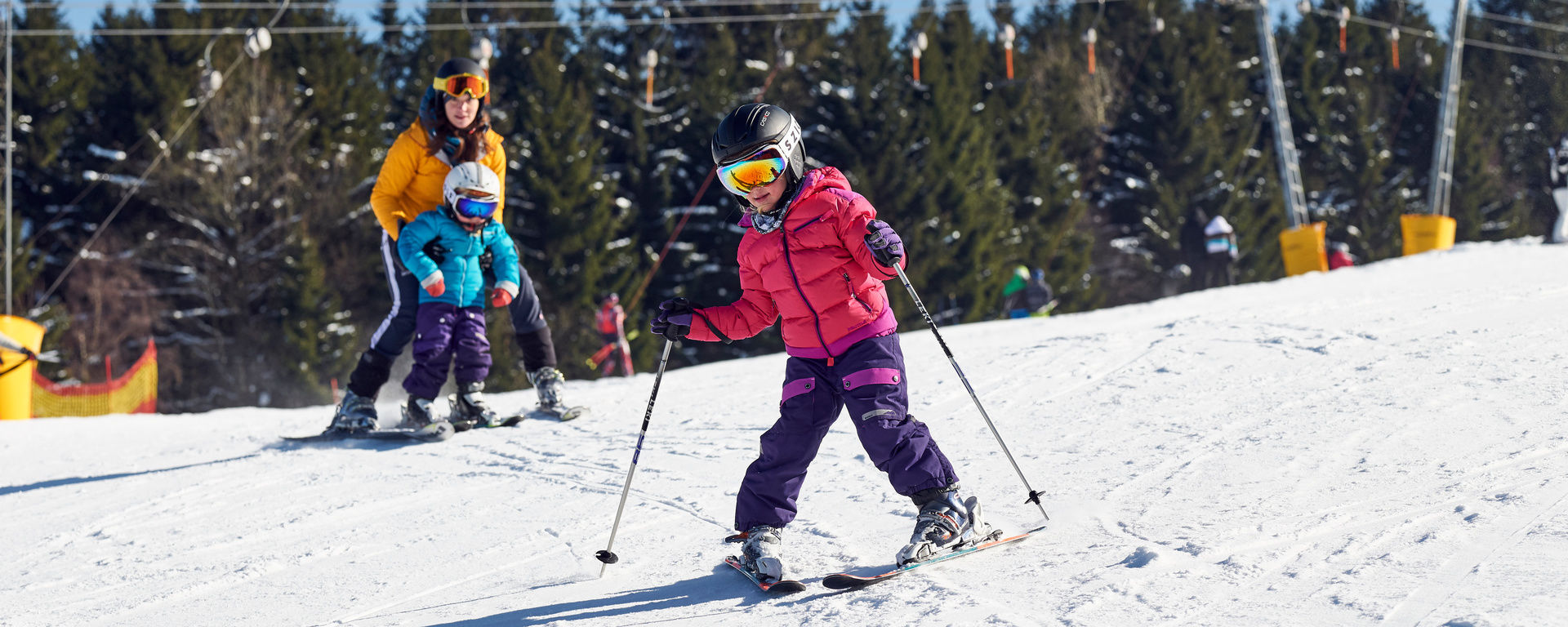 Eine Gruppe von Kindern lernt auf einem Übungshang in Bodenmais das Skifahren.
